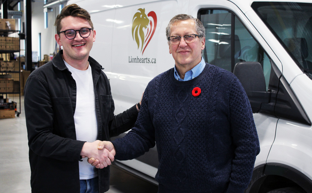 Brandon Maracle receiving cheque from Bob Burkholder for Lionhearts Inc